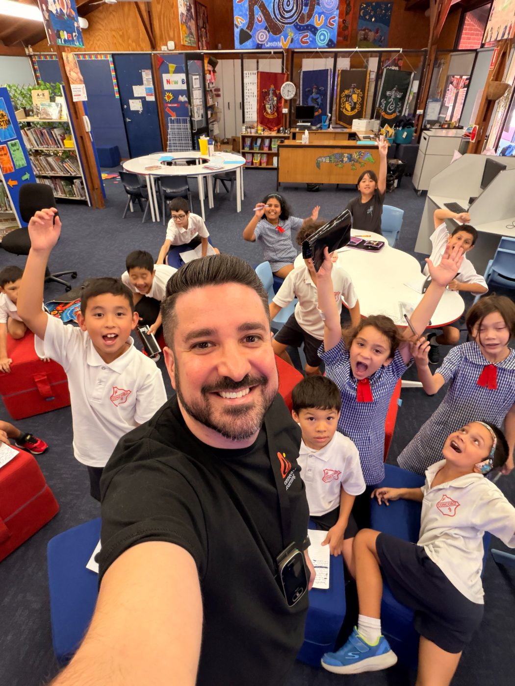 A Mighty Me facilitator with a class of cheering students