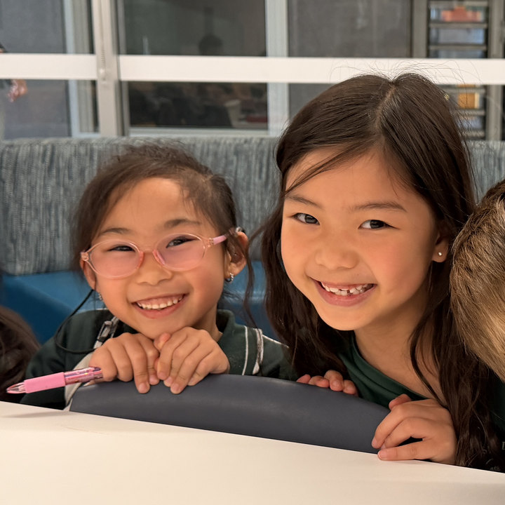 Two smiling students at a Mighty Me session