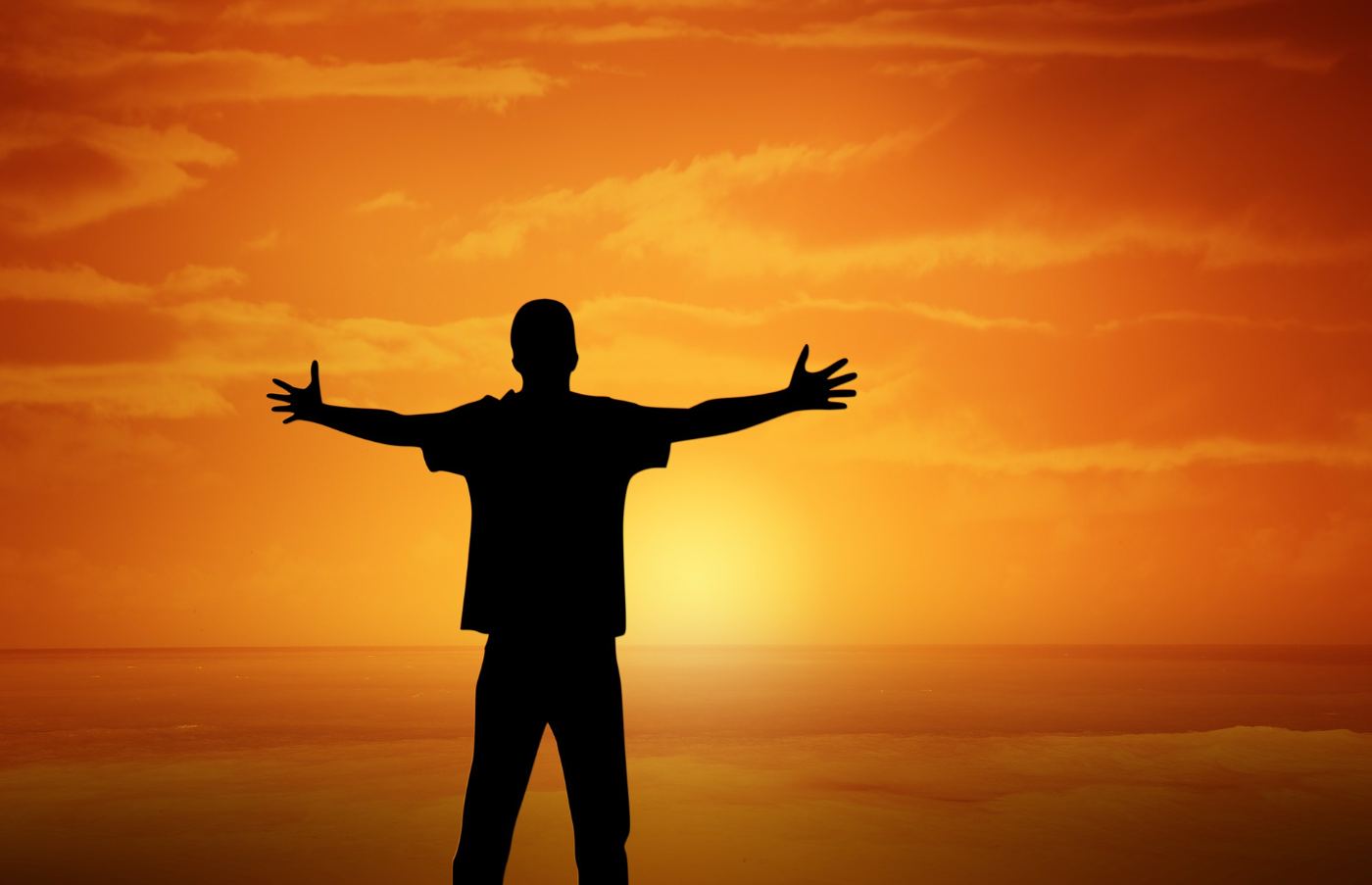 A child with arms outstretched at sunset